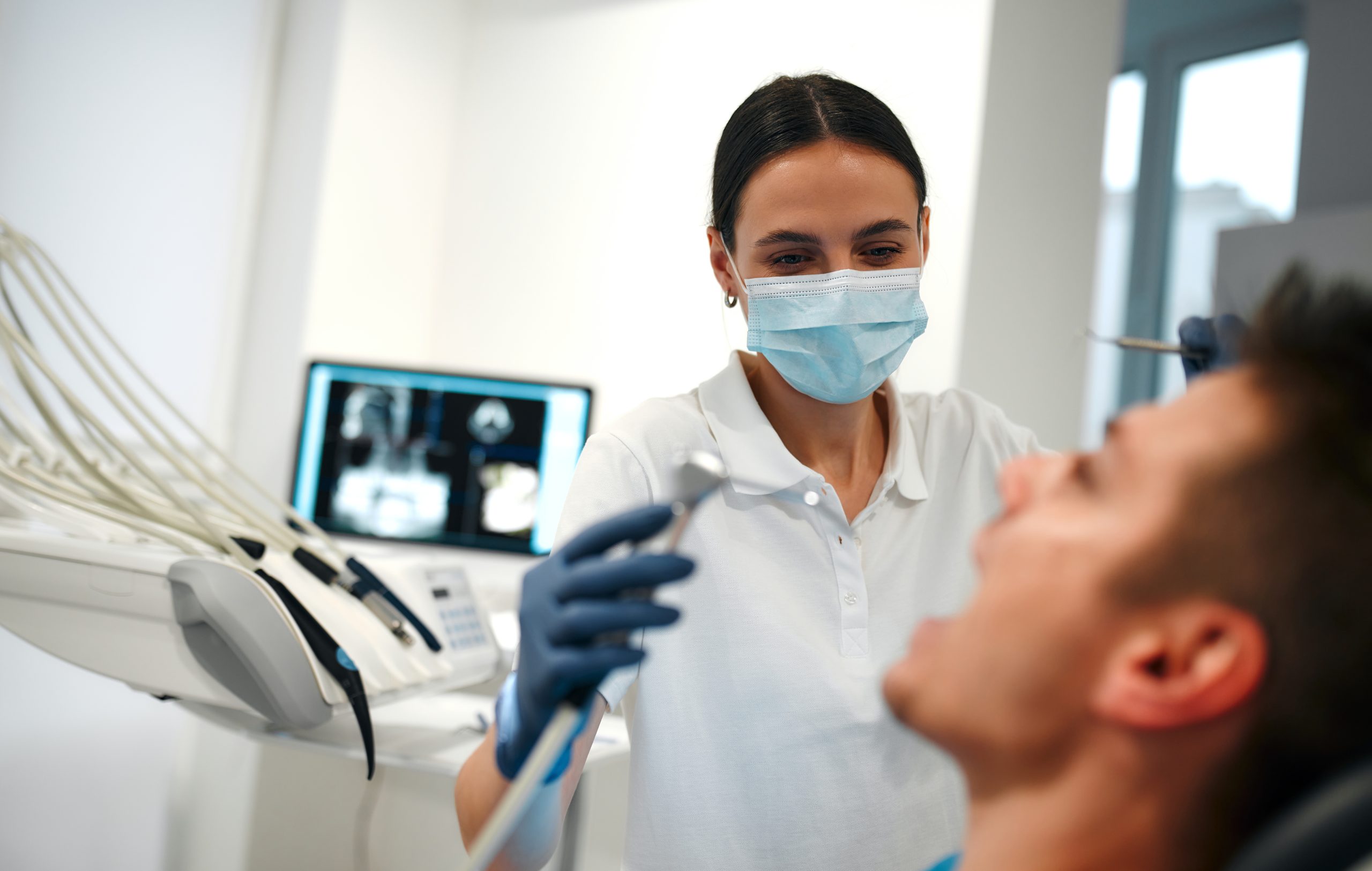 Female hygienist about to clean a patient’s teeth.
